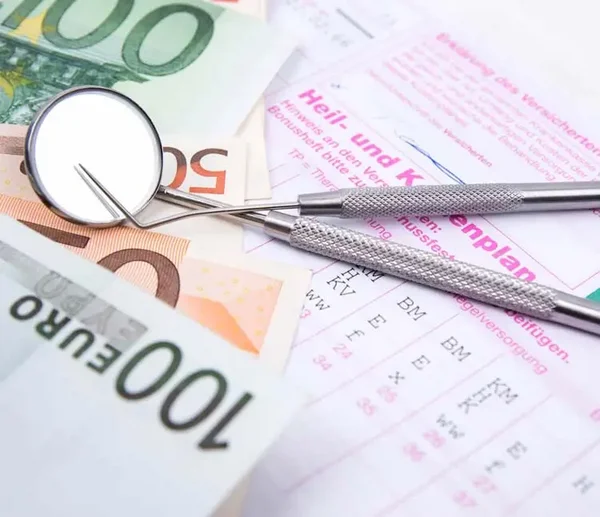 Zahnärztliche Instrumente auf verschiedenen Euro-Banknoten und einem Heil- und Kostenplan
