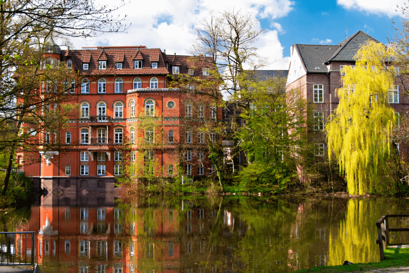 Blick vom Wasser auf ein rötliches Gebäude in Hamburg Bergedorf