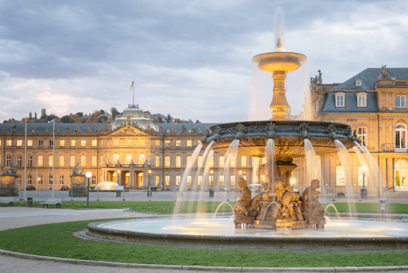 Königsplatz Stuttgart mit beleuchtetem Brunnen und Gebäude